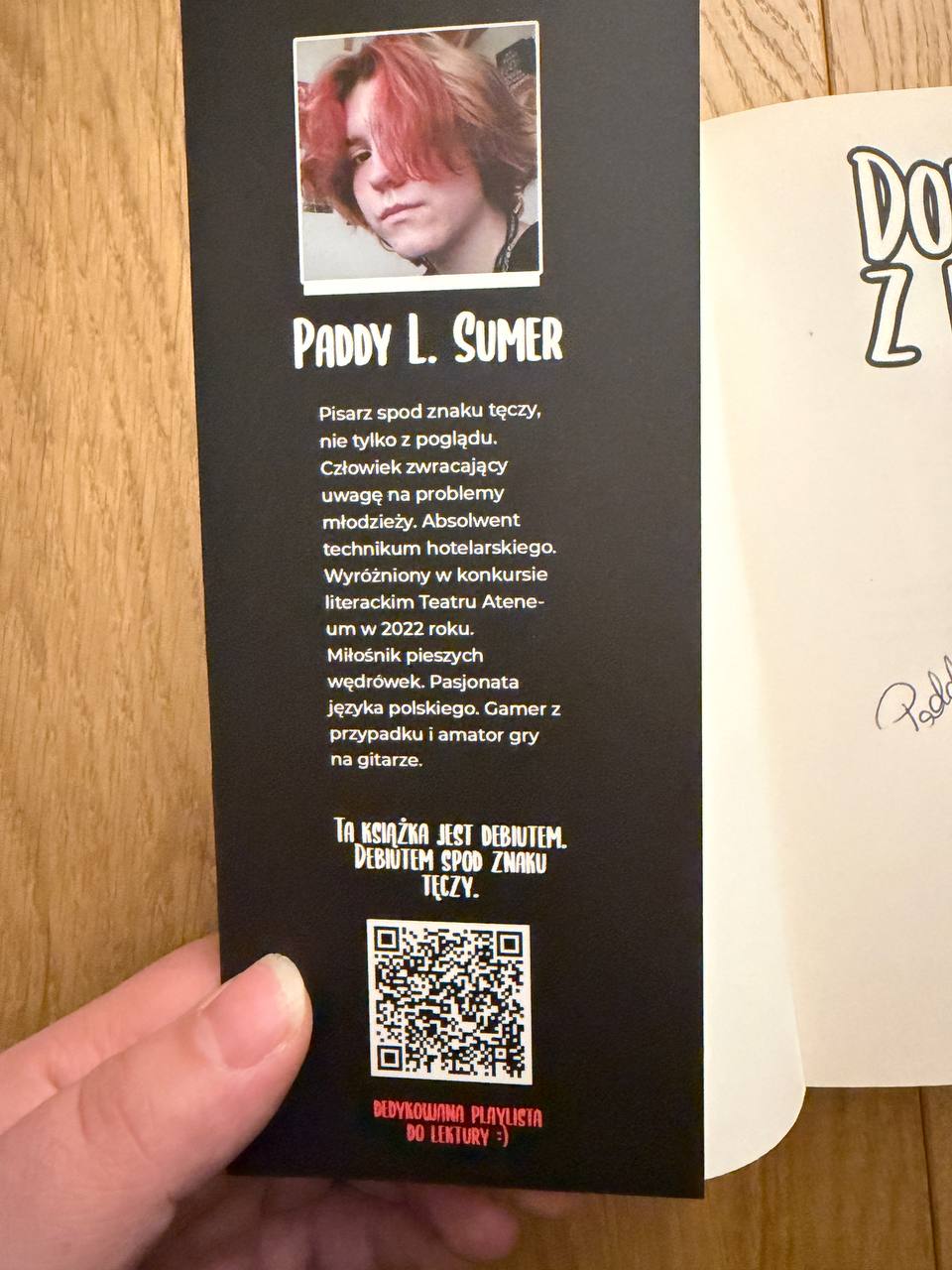Zakładka do książki z notą o autorze i kodem QR prowadzącym do dedykowanej playlisty
